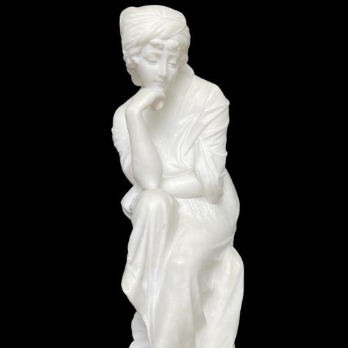 Seated alabaster figure of a young maiden.